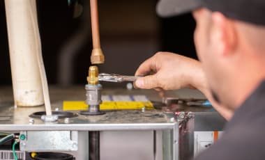 An air conditioning technician is working on a unit.
